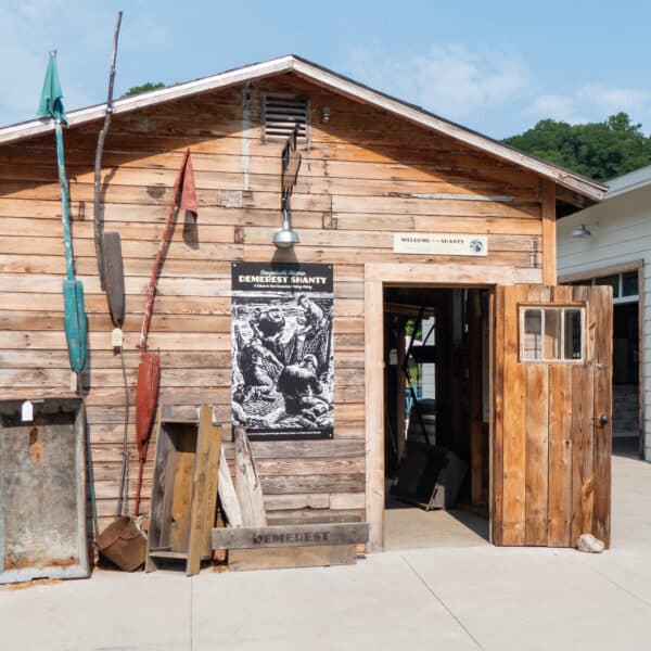 A front view of the Demerest Fishing Shanty, showing colored buoys and a poster of fishermen